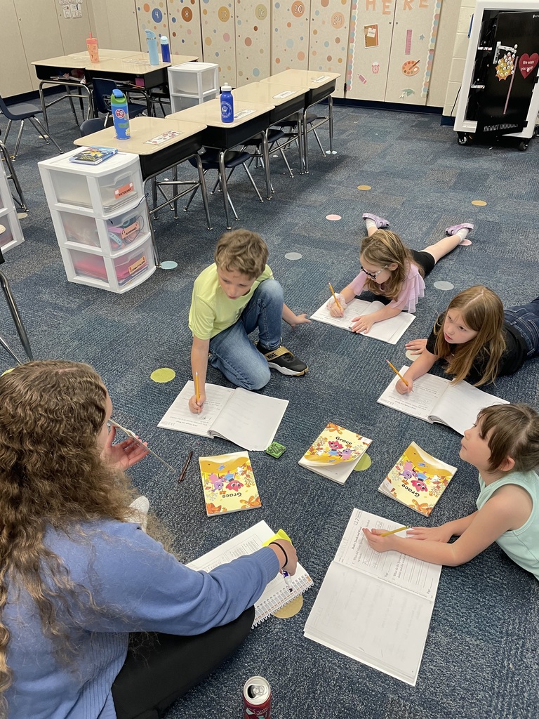 first grade students working in workbooks during class