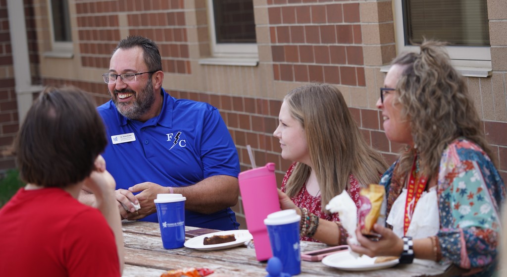 Kitley Staff laughing in conversation at cookout.