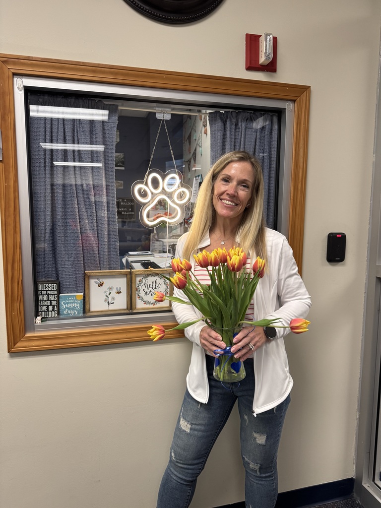 Mrs. Just holding flowers outside of her office window