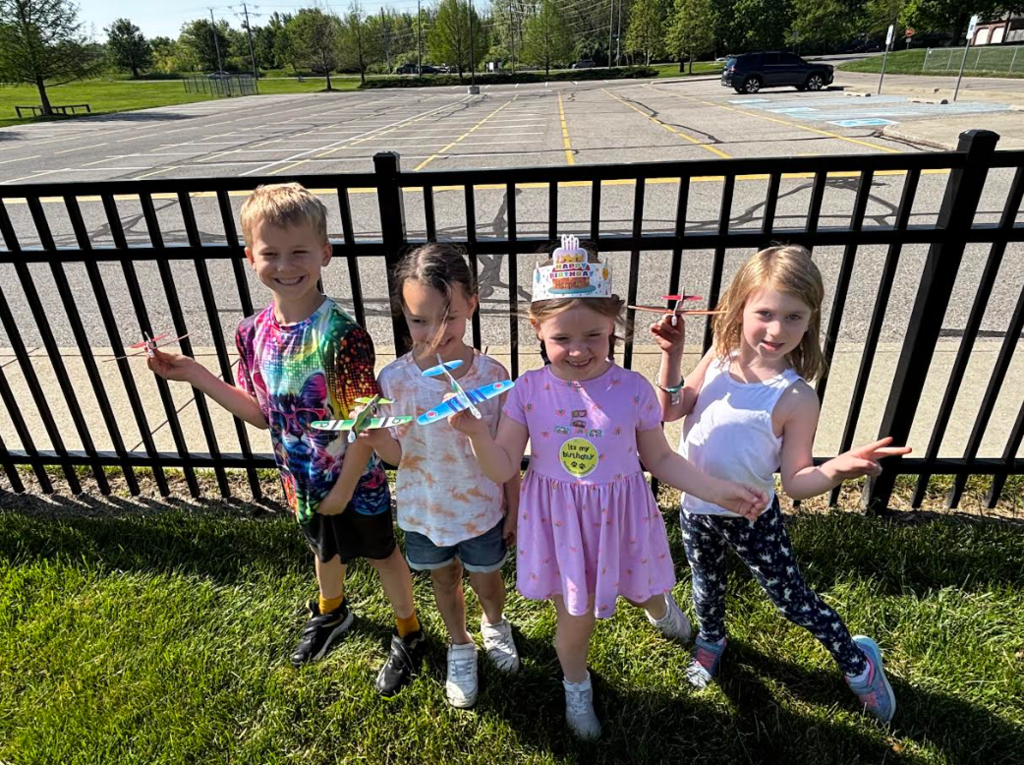 Miss Milligan's kindergarten class on A Day flying paper airplanes