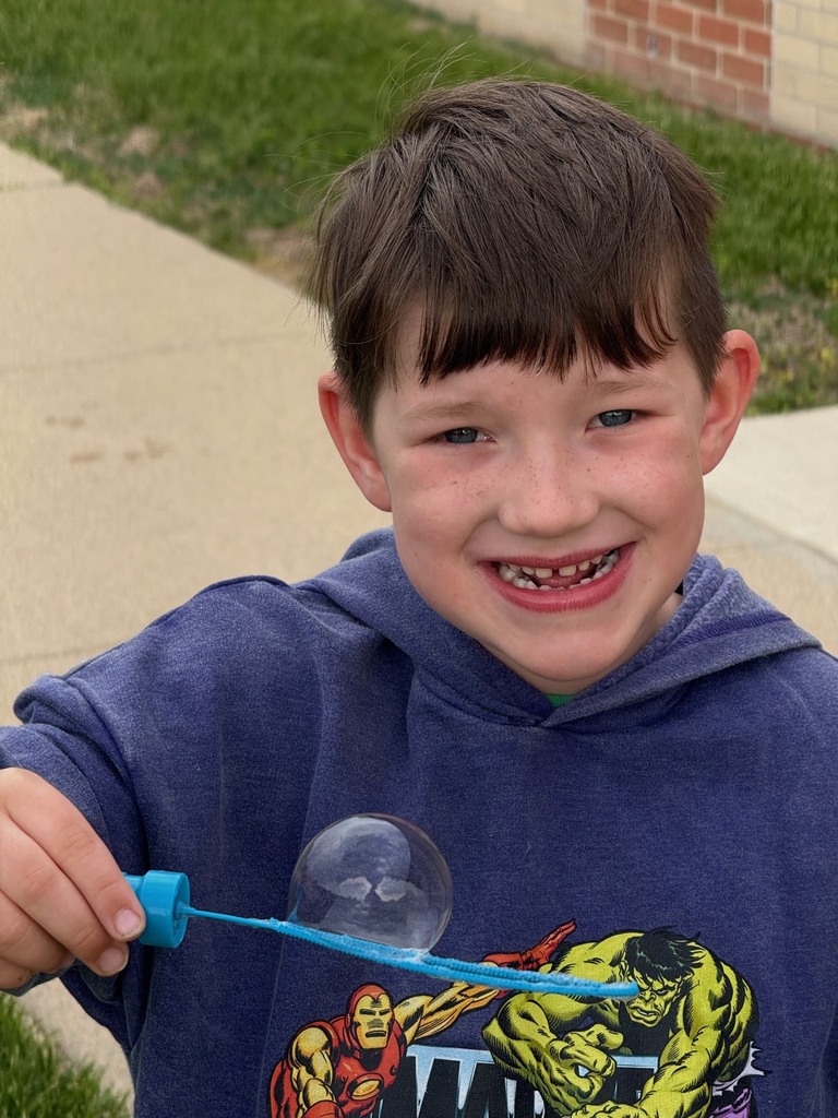 student blowing bubbles on B for Bubbles day