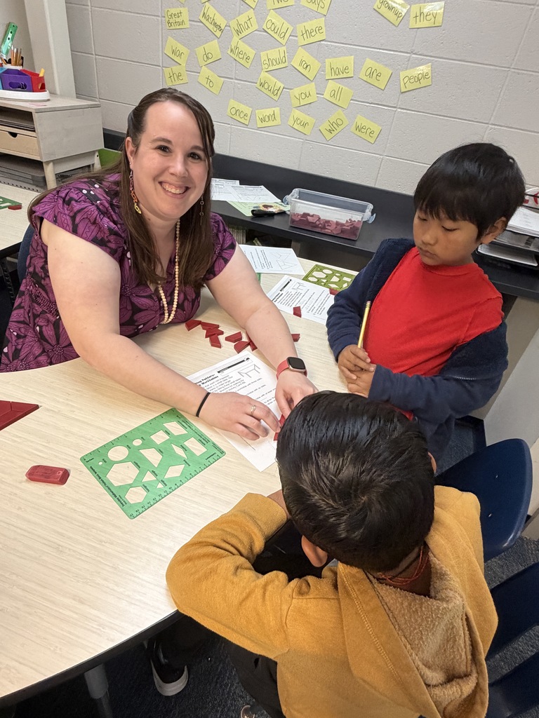 teacher working with 2 students at teacher table