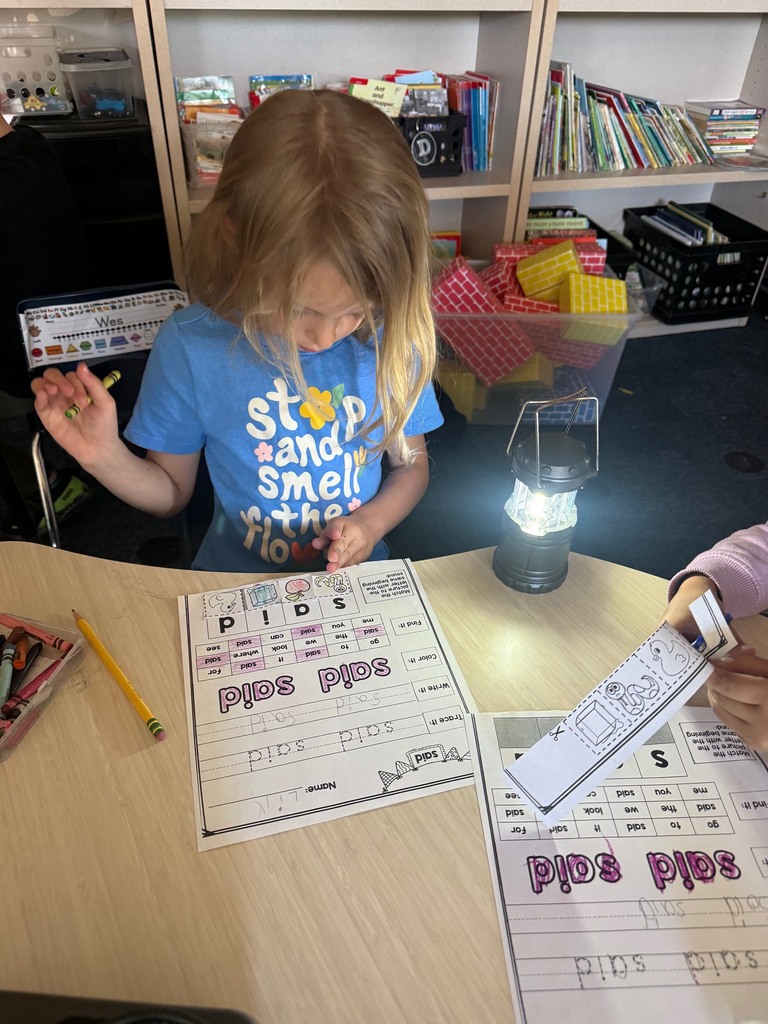 kindergarten student reading with a flashlight