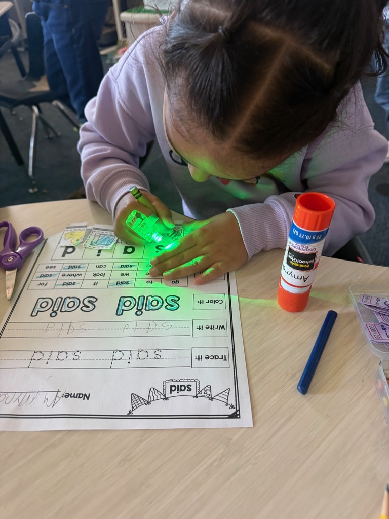 kindergarten student reading with a flashlight