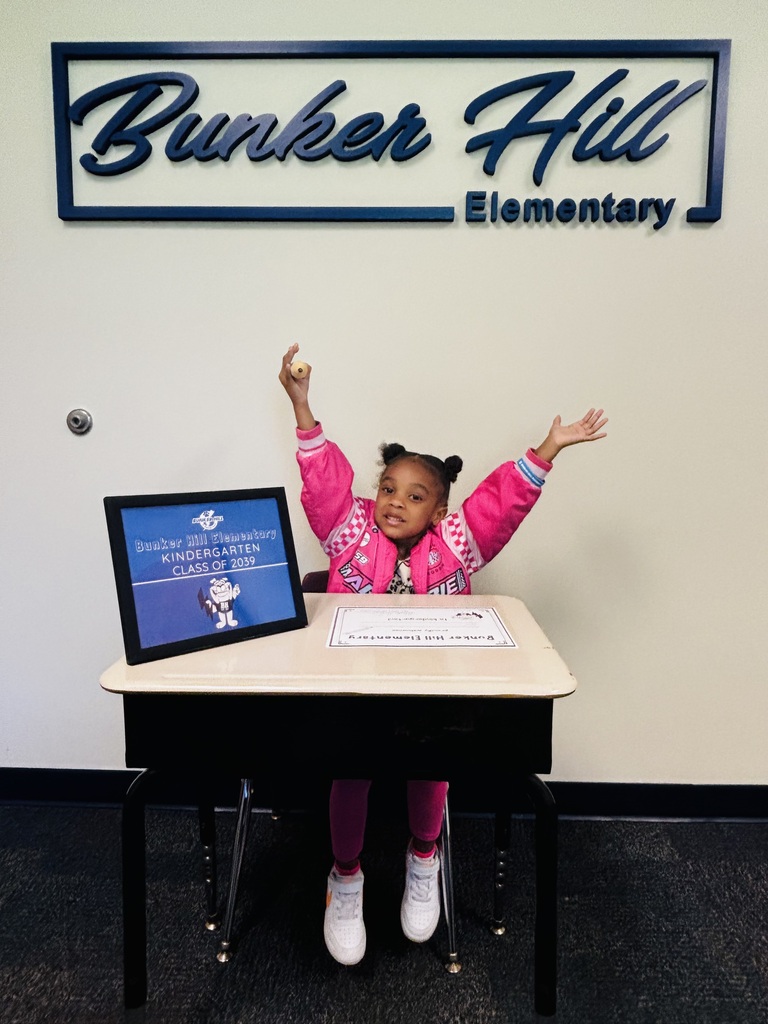 student signing their certificate during kindergarten screeners