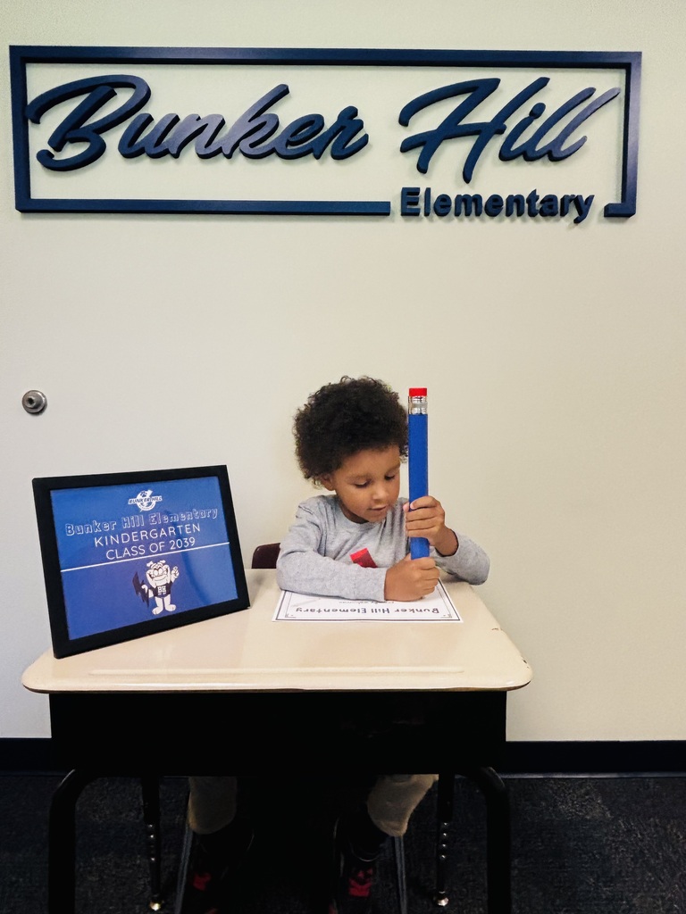 student signing their certificate during kindergarten screeners