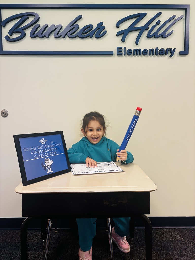 student signing their certificate during kindergarten screeners