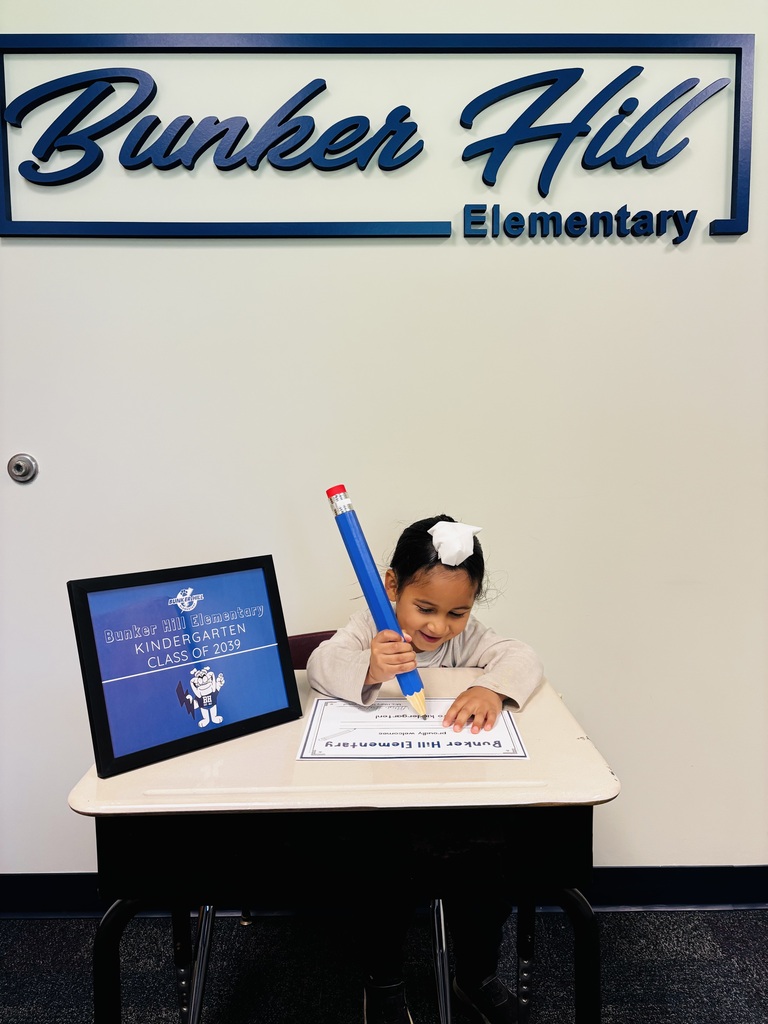 student signing their certificate during kindergarten screeners