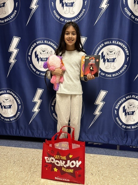 Book raffle winner smiling with their prize