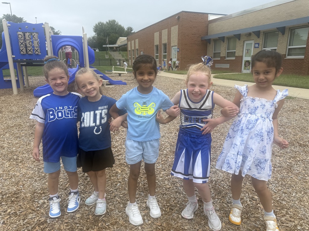 5 girls linking arms dressed in spirit wear smiling