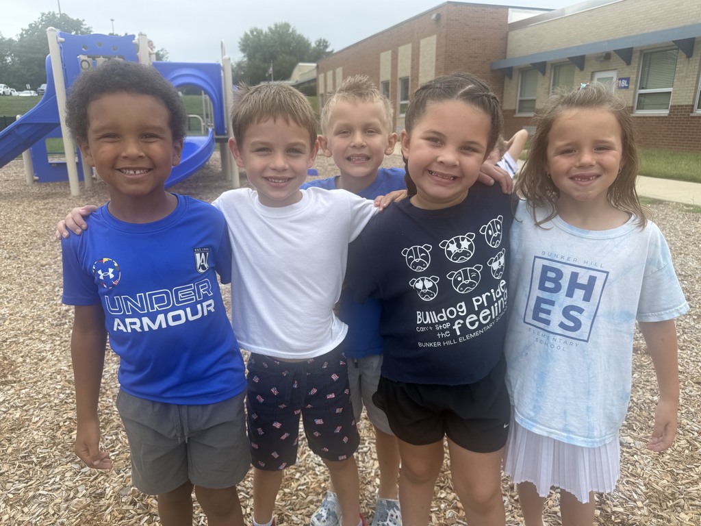 5 students smiling with their arms around each other dressed in spirit wear