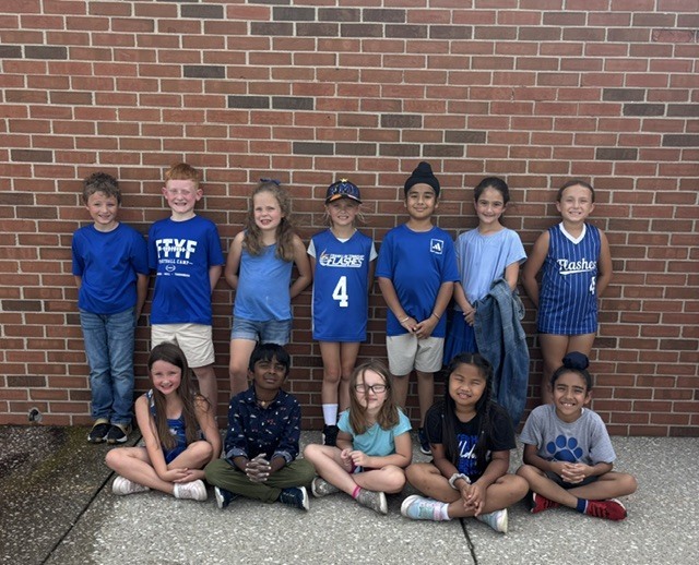 group of students smiling in two rows in spirit wear