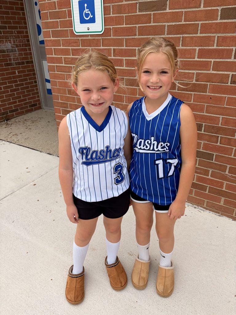 two girls in softball jerseys smiling together