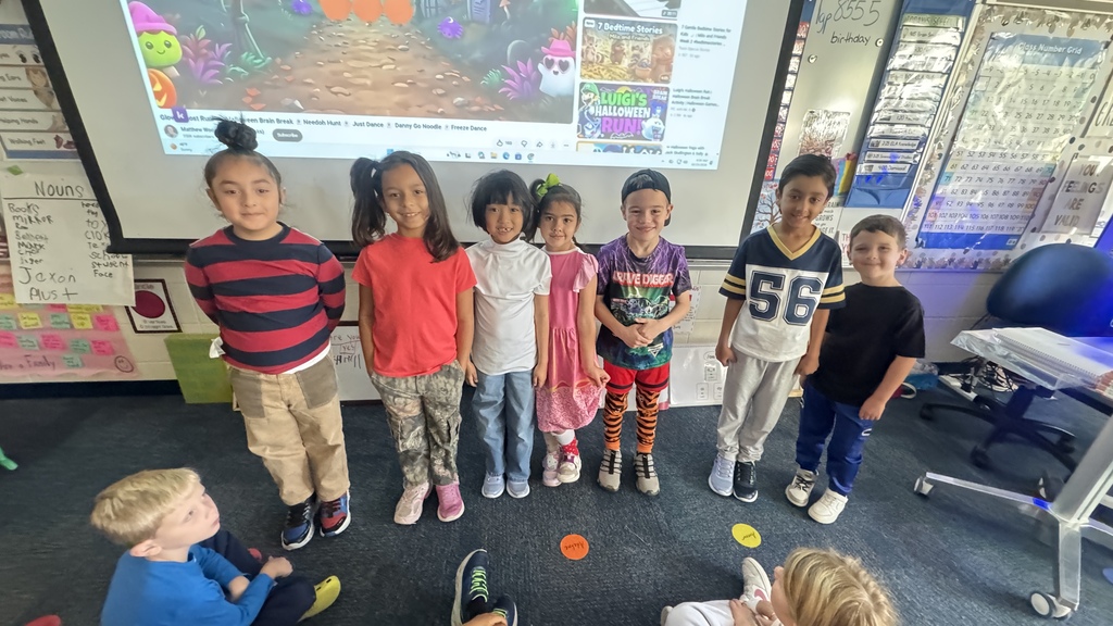 students standing in a line smiling while wearing mismatched clothing