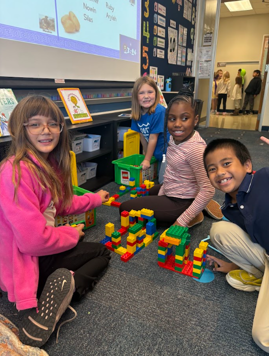 students building Grecian style buildings out of legos on the floor