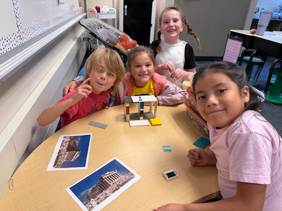 students building Grecian style buildings out of legos on a table