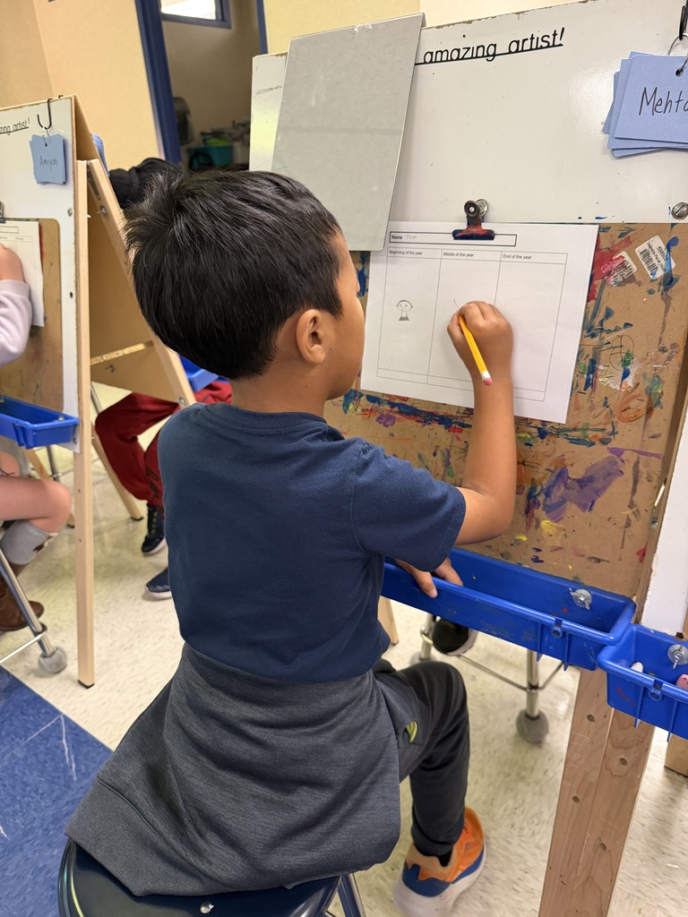 student sitting at an easel following the drawing directions on a worksheet