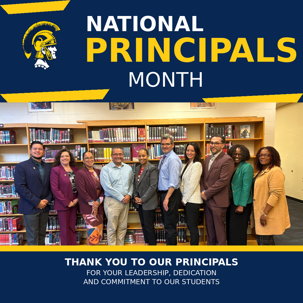 People stand in front of a library. A poster reads, "National Principals Month" and "Thank You to our Principals."