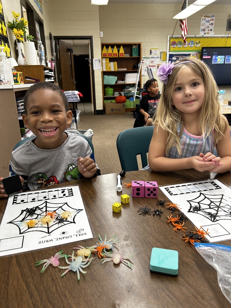 Two girls counting colorful plastic spiders