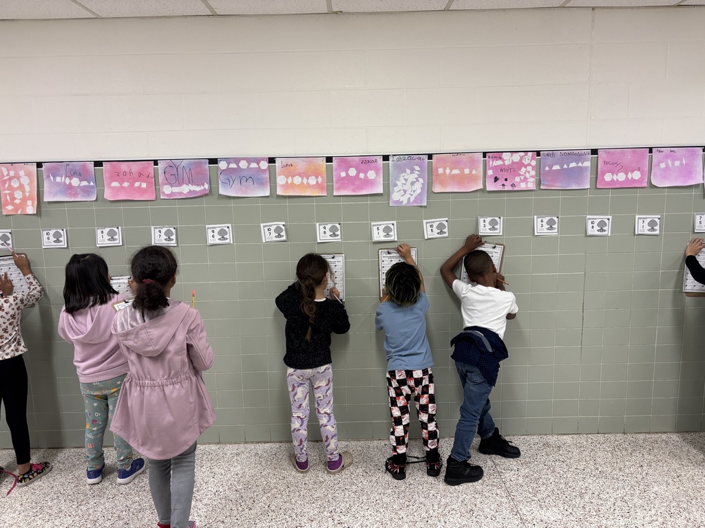 First Grade solving math problems in the hallway