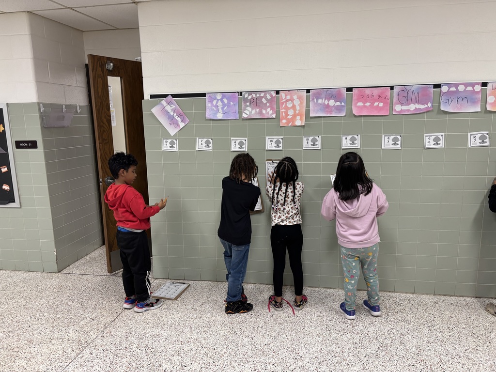 First Grade solving math problems in the hallway