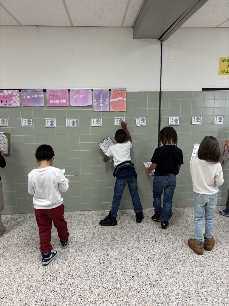 First Grade solving math problems in the hallway