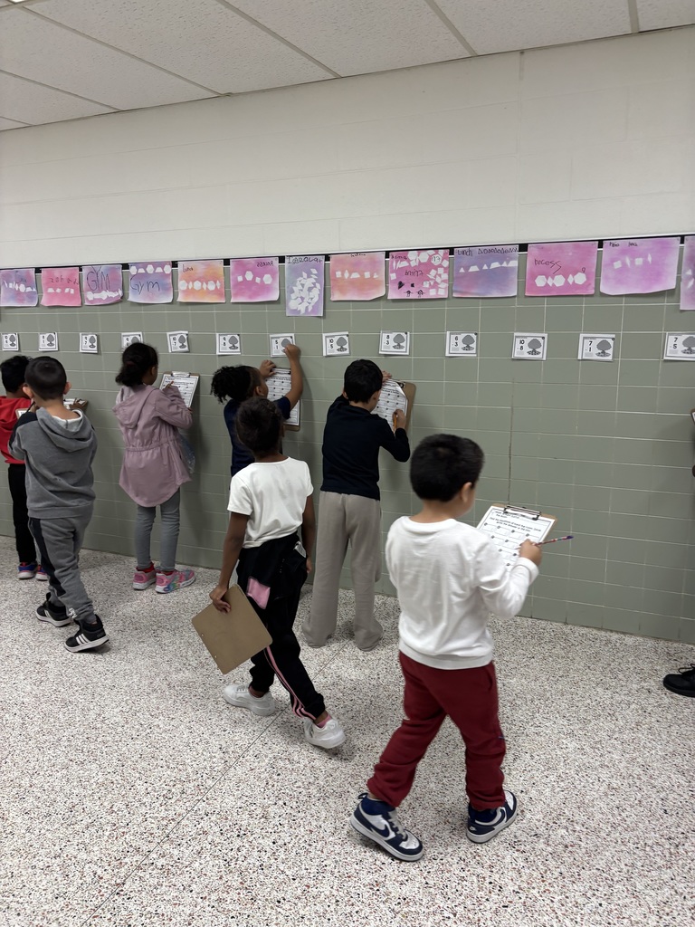 First Grade solving math problems in the hallway