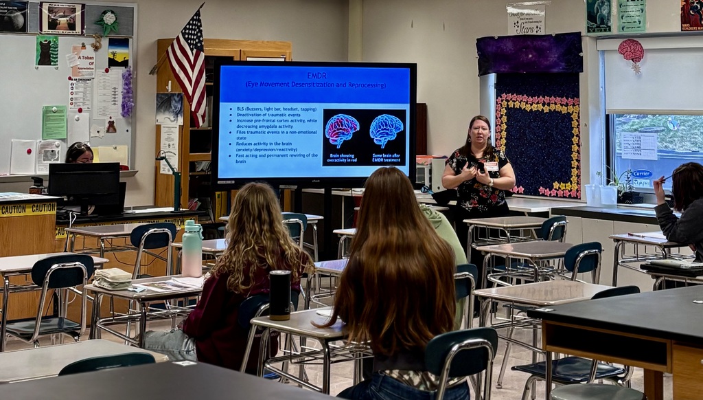 Presenter talking with students at career day.