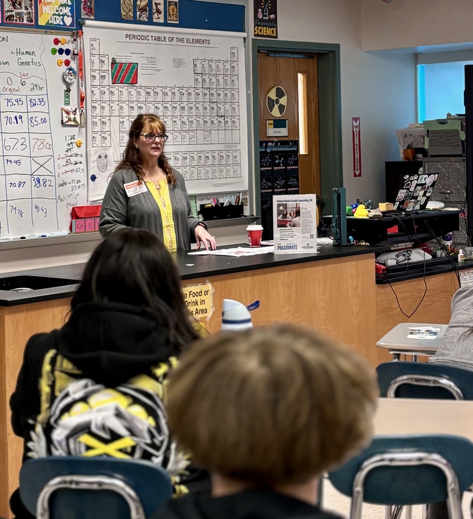 Presenter talking with students at career day.