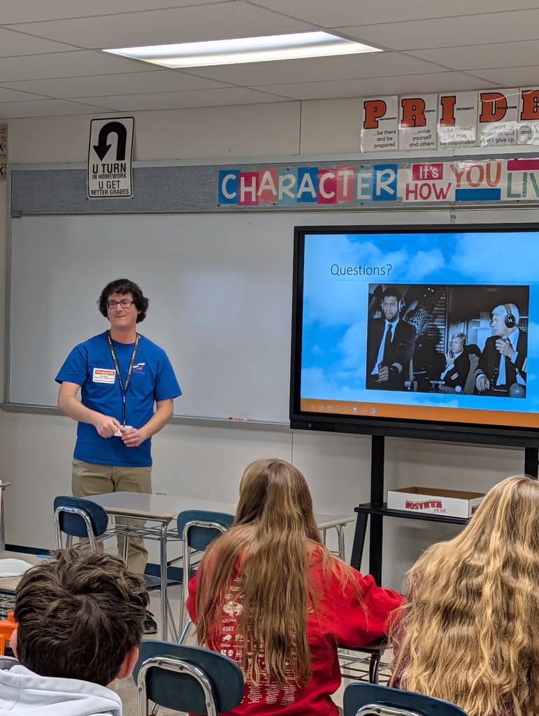Presenter talking with students at career day.