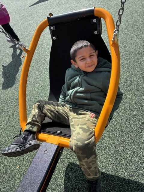 Wheelock students play on various pieces of equipment on the new Main St. playground.