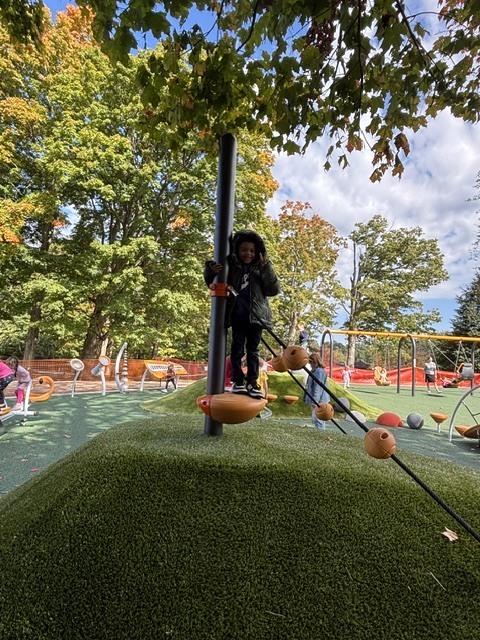 Wheelock students play on various pieces of equipment on the new Main St. playground.