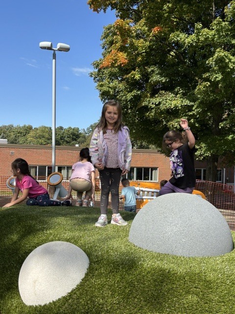 Wheelock students play on various pieces of equipment on the new Main St. playground.