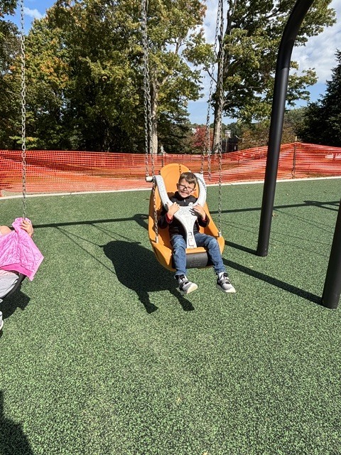 Wheelock students play on various pieces of equipment on the new Main St. playground.