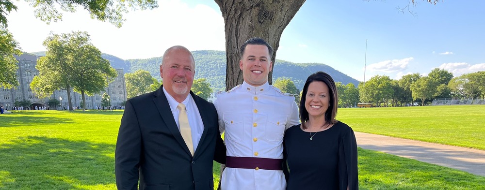 Man and woman stand with son who graduates from military school