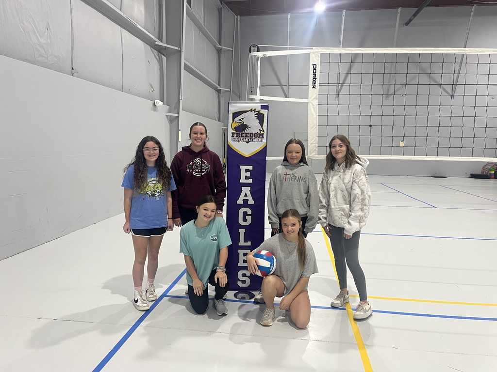 Students stand by volleyball net
