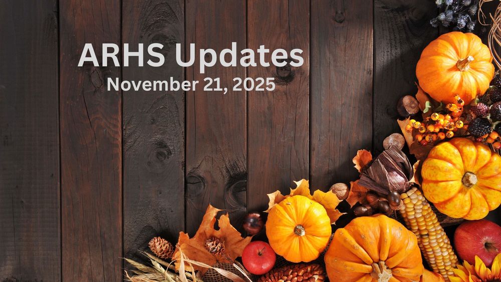 Pumpkins, berries, apples and fall leaves against a wood background.