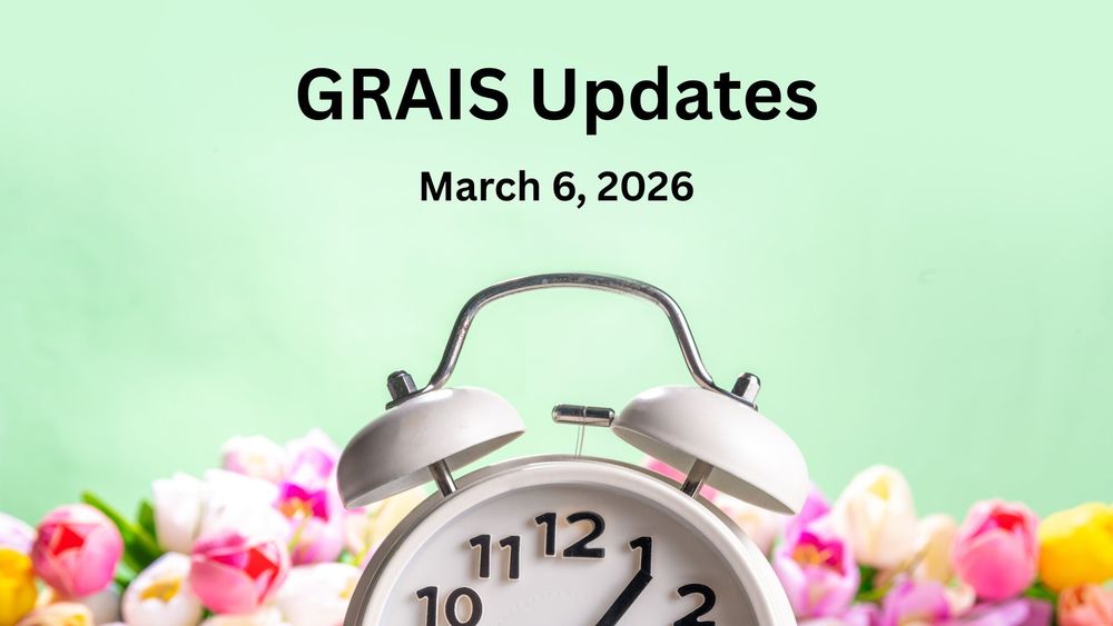 An old fashioned alarm clock against a background of spring tulips.