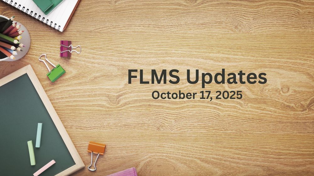 A chalk board and school supplies on a wooden desk top.