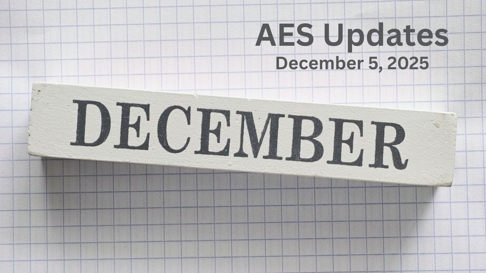 A wooden block with text December on it against a graph paper background.