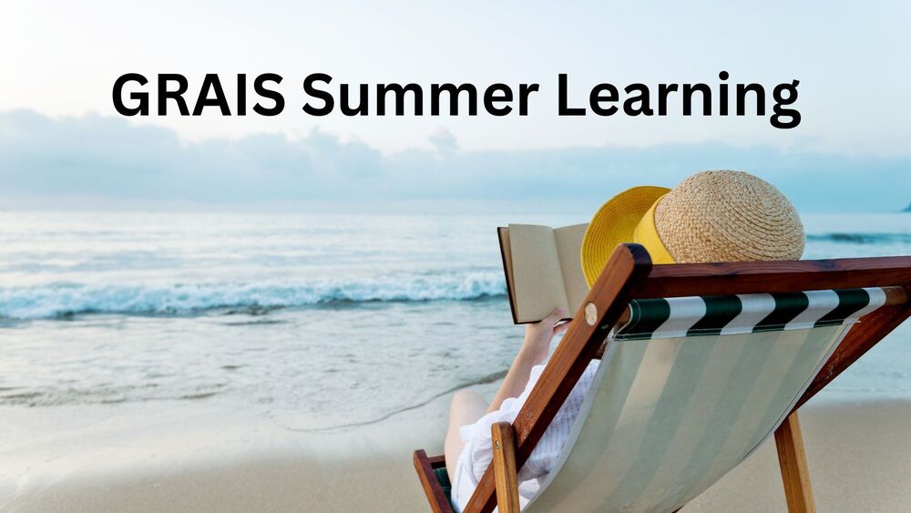 A person at the beach reading a book in a beach chair.