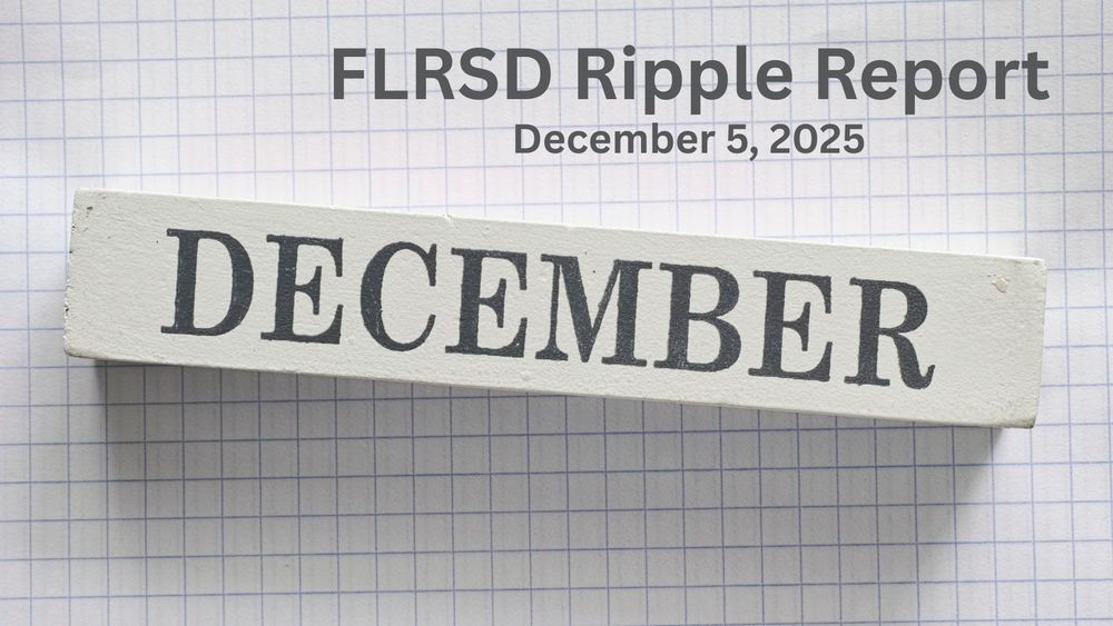 A wooden block with text December on it against a graph paper background.