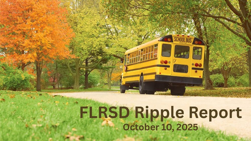 A school bus with fall color changing trees.