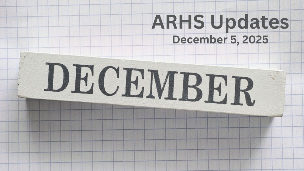 A white wooden block with text December on it against a graph paper background.