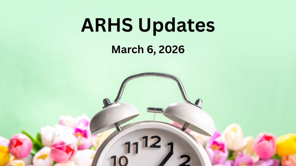 An old fashioned alarm clock against a background of spring tulips.