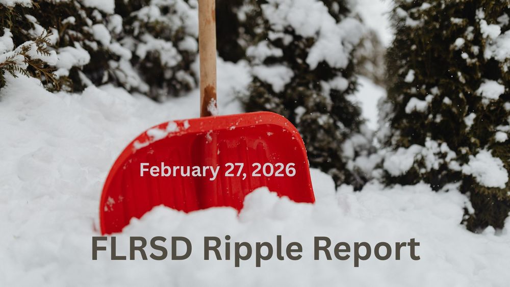 A snow shovel standing in the snow.