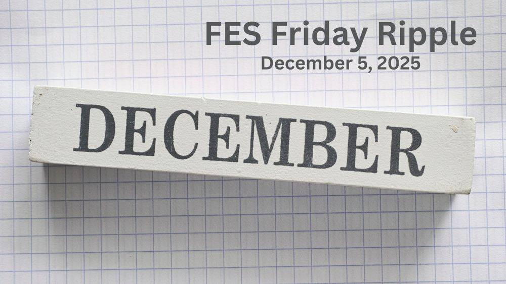 A wooden block with text December on it against a graph paper background.