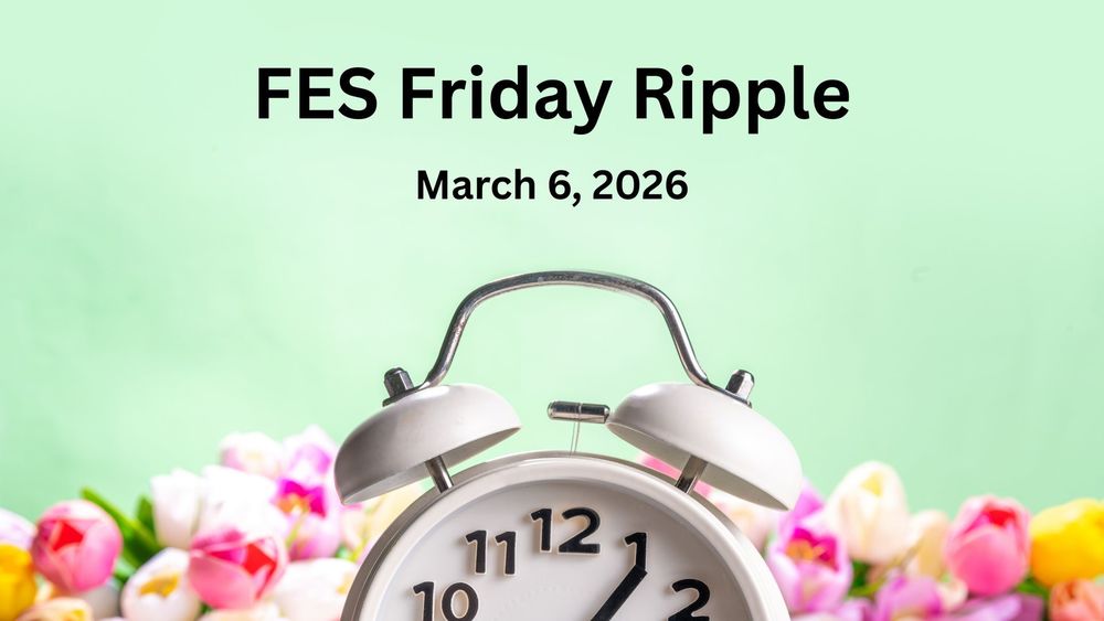 An old fashioned alarm clock against a background of spring tulips.