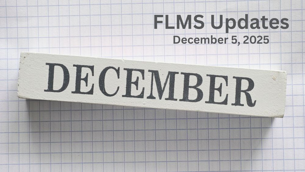 Wood block with text of December on it against a graph paper background.