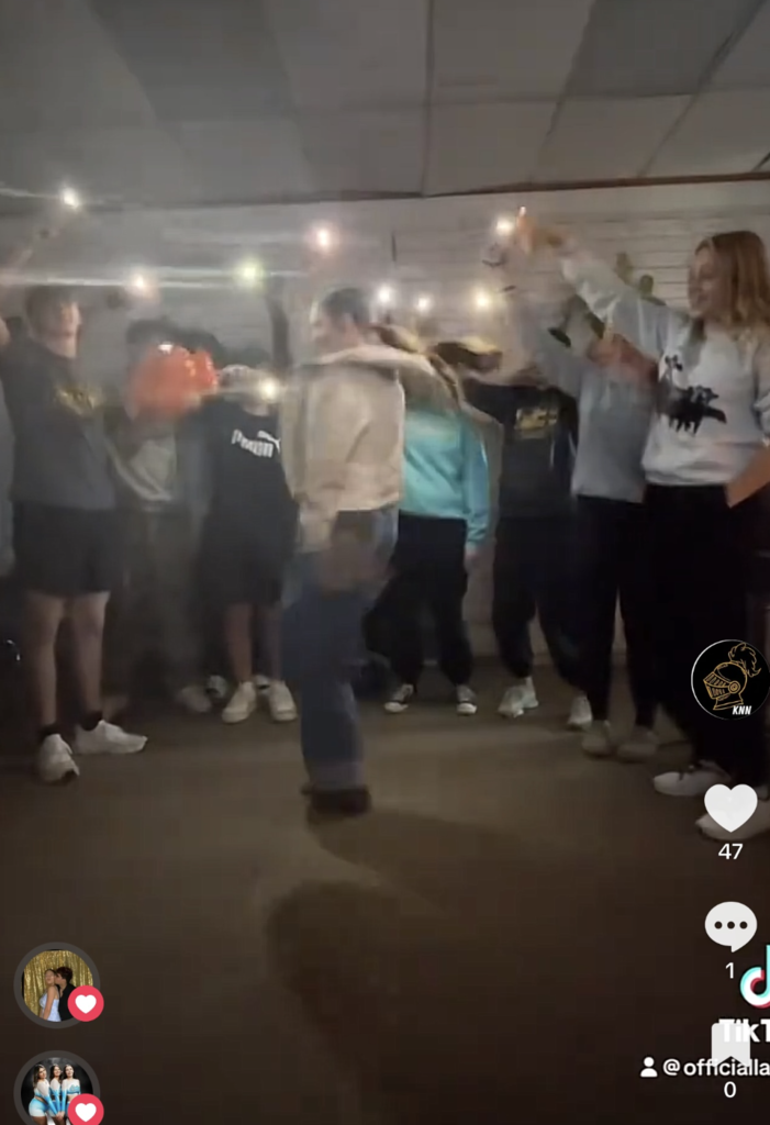 Student dancing in the middle of a circle of students for tik tok video